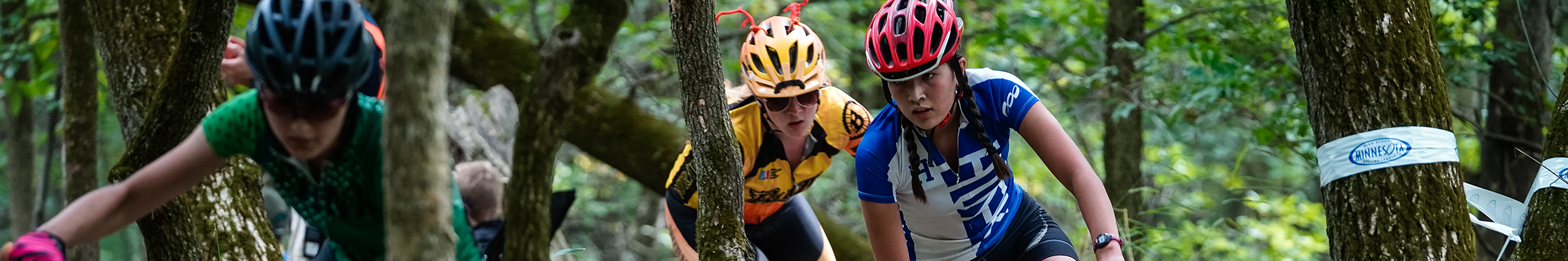 Mountain bikers winding through trees at Schindler's Way mtb park.